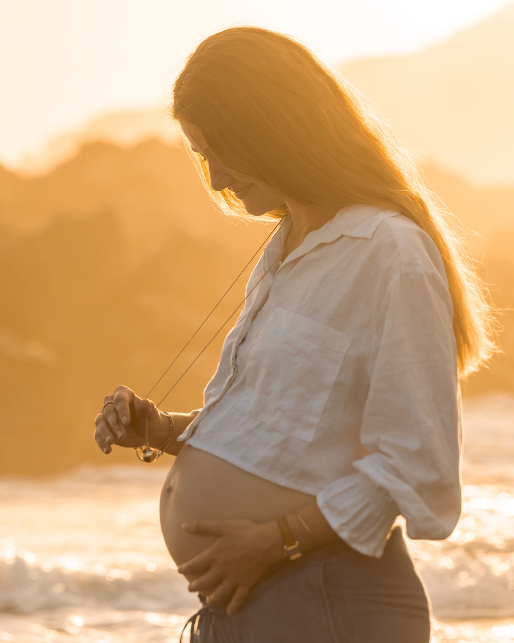 Future maman photographiée au bord de l’océan à La Réunion